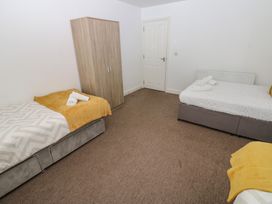 A bedroom with two beds and a wardrobe at Curwen Apartment in Workington