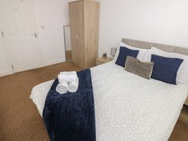 A bedroom with a bed and wardrobe at Curwen Apartment in Workington