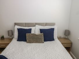 A bedroom with a bed and bedside tables at Curwen Apartment in Workington