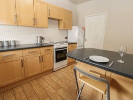 A kitchen with cabinets, stove, and countertop at Cumberland House Workington