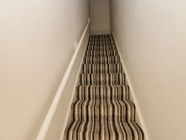 A stairway with carpet and a handrail at Cumberland House in Workington