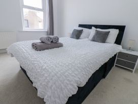 A bedroom with a bed and towels at Cumberland House in Workington