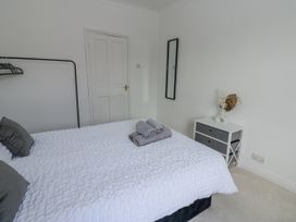 A bedroom with a bed, towels on it, and a chest of drawers at Cumberland House in Workington