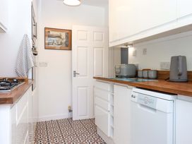 A kitchen with appliances and cabinets at Kenny Cottage in Dawlish