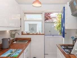 A kitchen with a sink and door leading to garden at Kenny Cottage in Dawlish