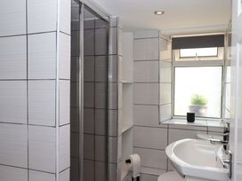 A bathroom with a shower, sink, and toilet at Kenny Cottage in Dawlish