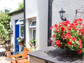 An outdoor area with flowers and a bench at Kenny Cottage in Dawlish