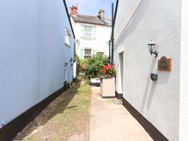 An alleyway between buildings with plants at Kenny Cottage in Dawlish