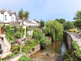 A scenic view of houses and gardens by a river at Kenny Cottage in Dawlish