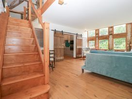A living room with a staircase and windows at The Art House in Leominster