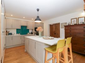 A kitchen with cabinets and bar stools at The Art House in Leominster