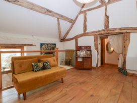 A living room with a sofa and wooden beams at The Art House in Leominster