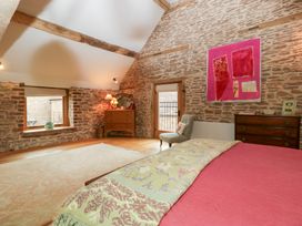 A bedroom with a bed, dresser, and armchair at The Art House in Leominster