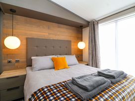 A bedroom with a bed and bedside lamps at Hazelnut Lodge in Chipping Norton