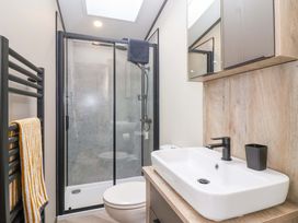 A bathroom with a shower and sink at Hazelnut Lodge in Chipping Norton