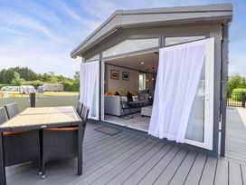 A living room with a sofa and sliding doors at Hazelnut Lodge Chipping Norton