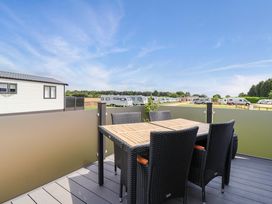An outdoor seating area with table and chairs at Hazelnut Lodge in Chipping Norton