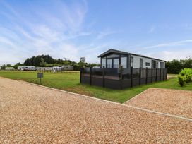 An outdoor scene with a holiday lodge and caravans at Hazelnut Lodge in Chipping Norton