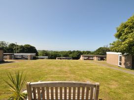 A garden with grass and a bench at 8 Hillside in Bude