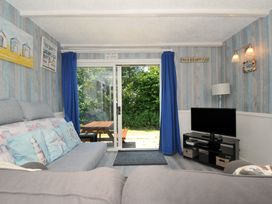 A snug with a sofa and a tv at 8 Hillside in Bude