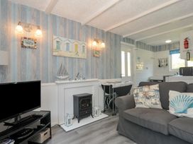 A living room with a sofa and television at 8 Hillside in Bude
