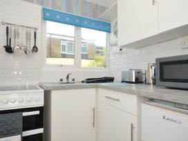 A kitchen with stove, sink and appliances at 8 Hillside in Bude