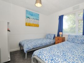 A bedroom with two beds and a bedside table at 8 Hillside in Bude
