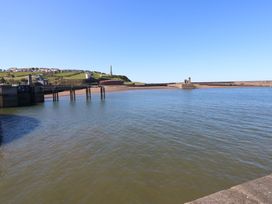 A view of a pier and water with hills in the background at Georgian Town House in Whitehaven