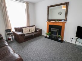 A living room with a fireplace and mirror at Georgian Town House in Whitehaven