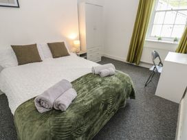 A bedroom with a bed and wardrobe at Georgian Town House in Whitehaven