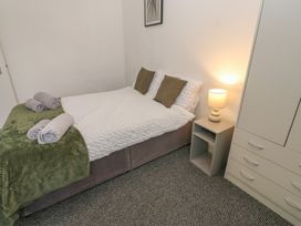 A bedroom with a bed and nightstand at Georgian Town House in Whitehaven