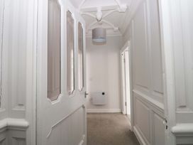 A hallway with a door and a light fixture at Lowther Suite Whitehaven