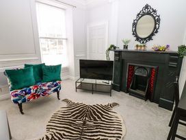 A living room with a sofa and television at Lowther Suite Whitehaven