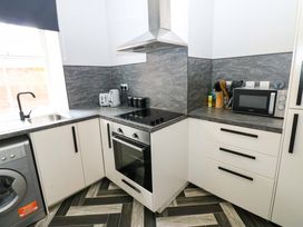 A kitchen with stove and microwave at Lowther Suite in Whitehaven