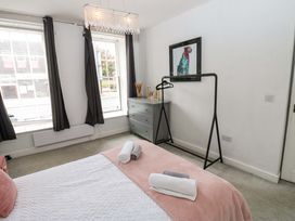 A bedroom with a bed and a dresser at Lowther Suite in Whitehaven