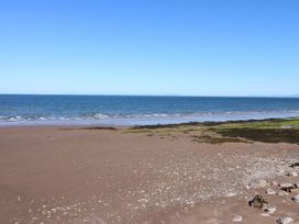 A beach with sand and sea at Lowther Suite in Whitehaven