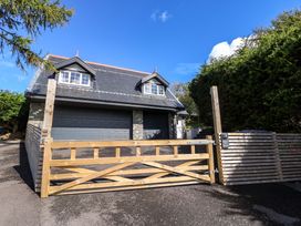 A house with a wooden gate and driveway at The Gatekeepers Cottage - Skerry Vore Bryn Pydew near Llandudno Junction