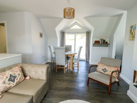 A dining room with a table and chairs at The Gatekeepers Cottage - Skerry Vore in Bryn Pydew near Llandudno Junction