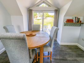 A dining room with a round table and chairs at The Gatekeepers Cottage - Skerry Vore in Bryn Pydew near Llandudno Junction