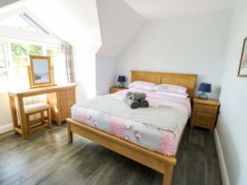 A bedroom with a bed and dresser at The Gatekeepers Cottage - Skerry Vore, Bryn Pydew near Llandudno Junction