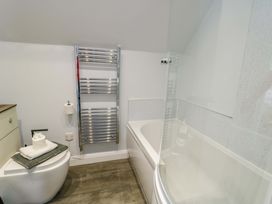 A bathroom with a toilet, bathtub, and towel rack at The Gatekeepers Cottage - Skerry Vore near Llandudno Junction