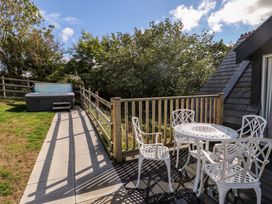 An outdoor area with a hot tub and seating at The Gatekeepers Cottage - Skerry Vore in Bryn Pydew near Llandudno Junction