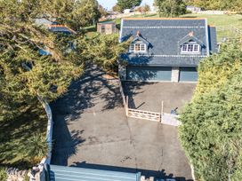An exterior view of a house with a garage and driveway at The Gatekeepers Cottage - Skerry Vore in Bryn Pydew near Llandudno Junction
