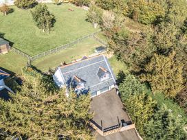 An aerial view of a house with garden and trees at The Gatekeepers Cottage - Skerry Vore near Bryn Pydew, Llandudno Junction