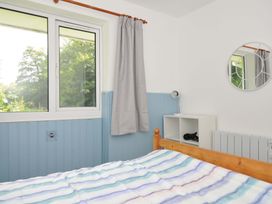 A bedroom with a bed and window at 4 Rosecraddoc Lodge Holiday Bungalows in Liskeard