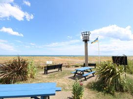 An outdoor area with a torch, bench, and picnic table at No. 2 - Seaview in Kessingland
