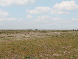 An outdoor area with grass and gravel and vehicles in the distance at No. 2 - Seaview Kessingland