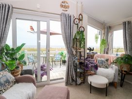 A living room with a view of the outdoor patio at No. 2 - Seaview Kessingland