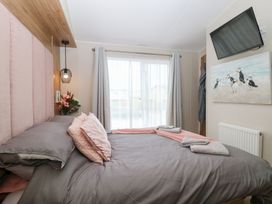 A bedroom with a bed and wall art at No. 2 - Seaview Kessingland