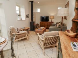 A living room with a television and seating area at Watermill Cottage in North Charlton
